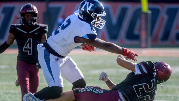 Nazareth Academy athlete Justin Taylor stiff arms a defender while running with the football.